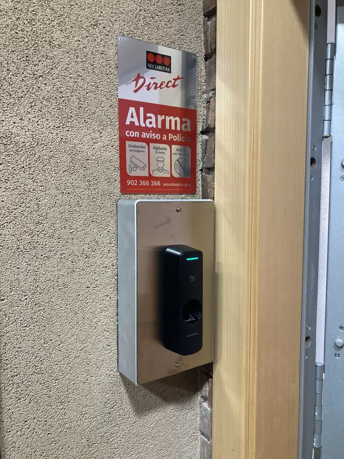 Terminal biométrico de huella en una puerta Lector biométrico de huella dactilar instalado junto a la puerta de una oficina para el control de accesos